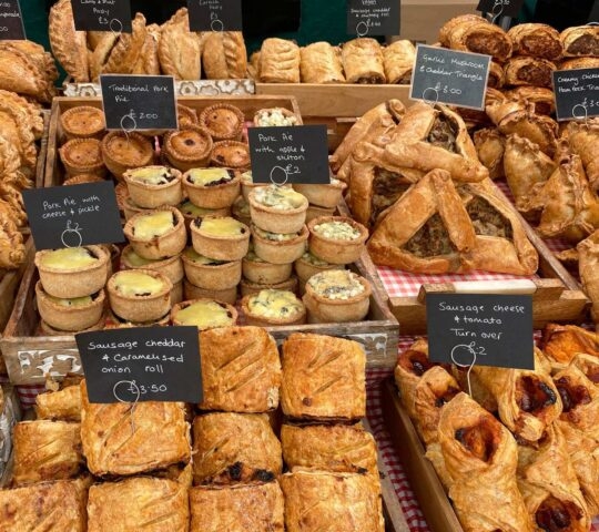 A market stall selling pies and savoury bakes in Malton, North Yorkshire