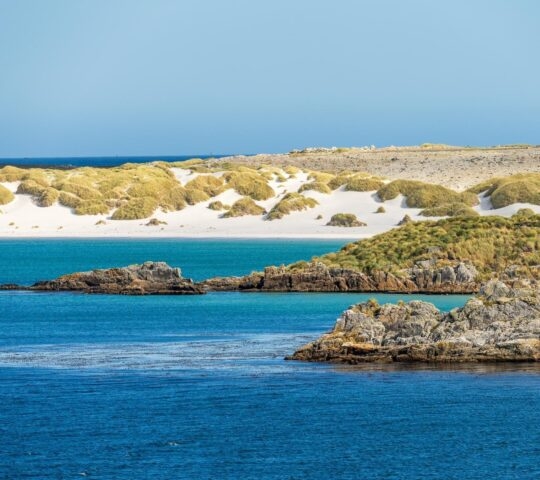 Sandy beaches and rocks when approaching the port of Stanley on the Falkland Islands from the ocean .