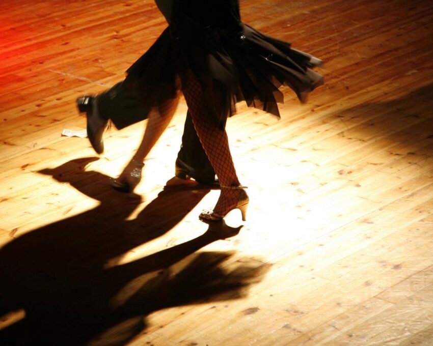 A close up of a couple doing the tango dance.