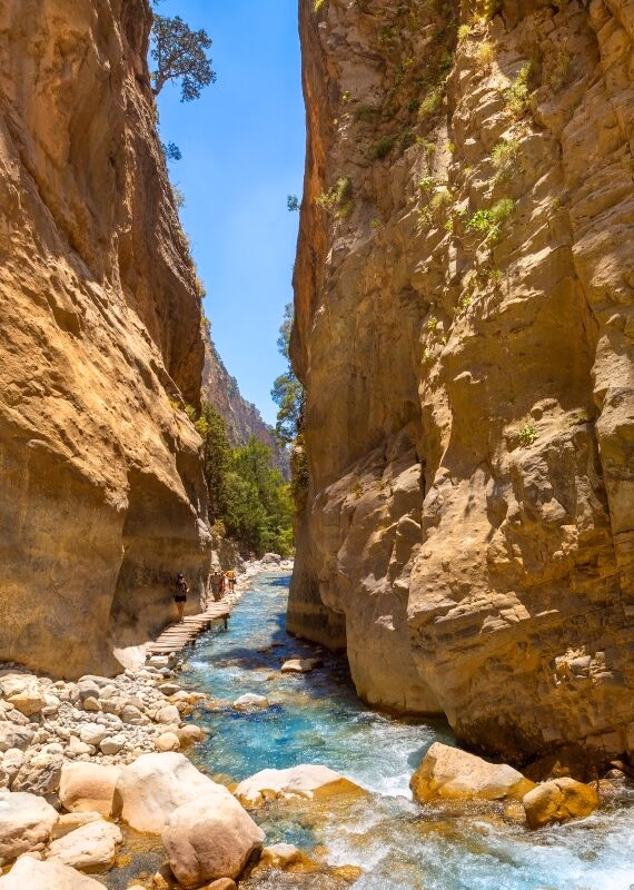 A blue river running through Samaria Gorge in Crete