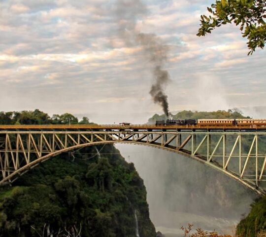 Train at Victoria falls, crossing a bridge.