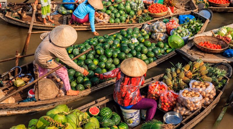 Vietnamese women selling fruit from small boats
