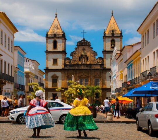 View of a church in Pelourinho, Salvador, with two brightly dressed women