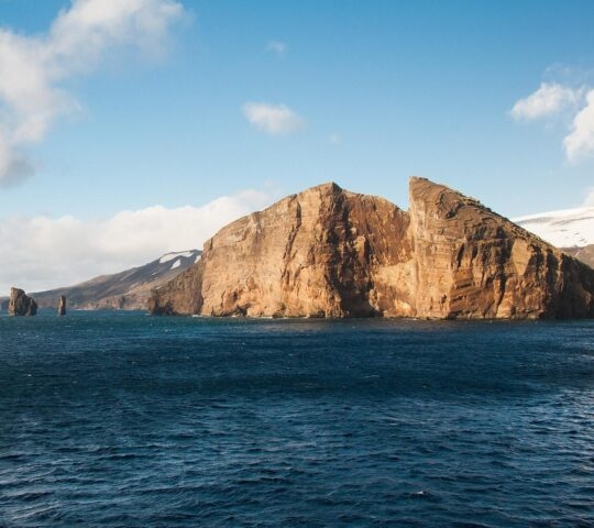 An image of the rugged coastline of Deception Island in Antarctica from the sea.