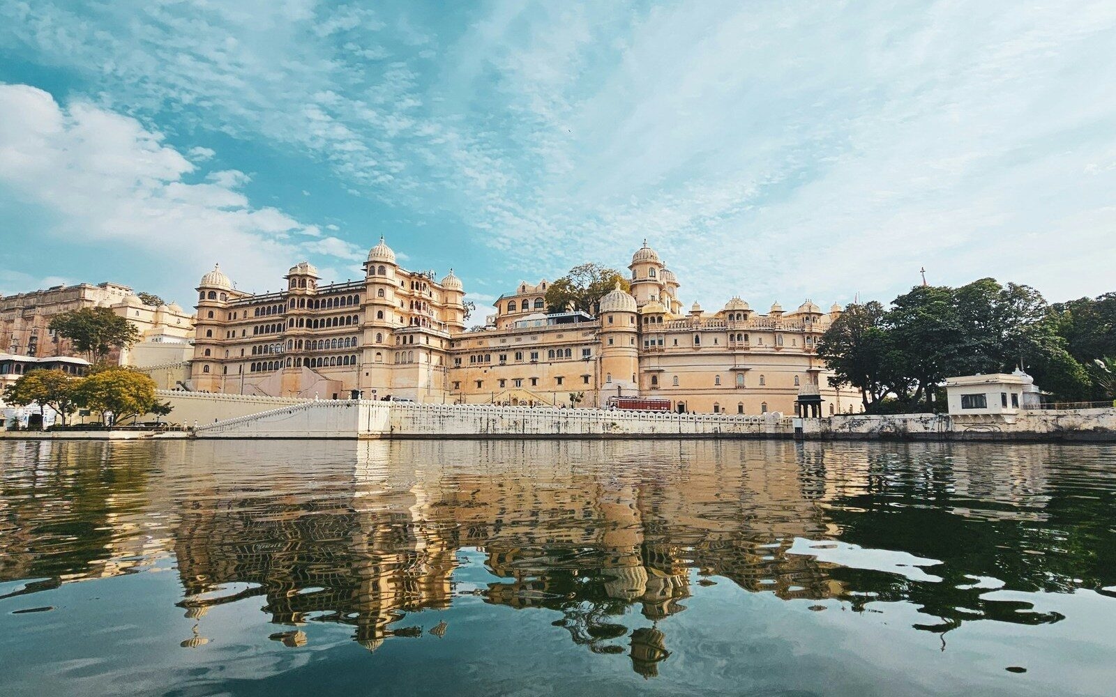 The grand City Palace of Udaipur in the tranquil waters of Lake Pichola.