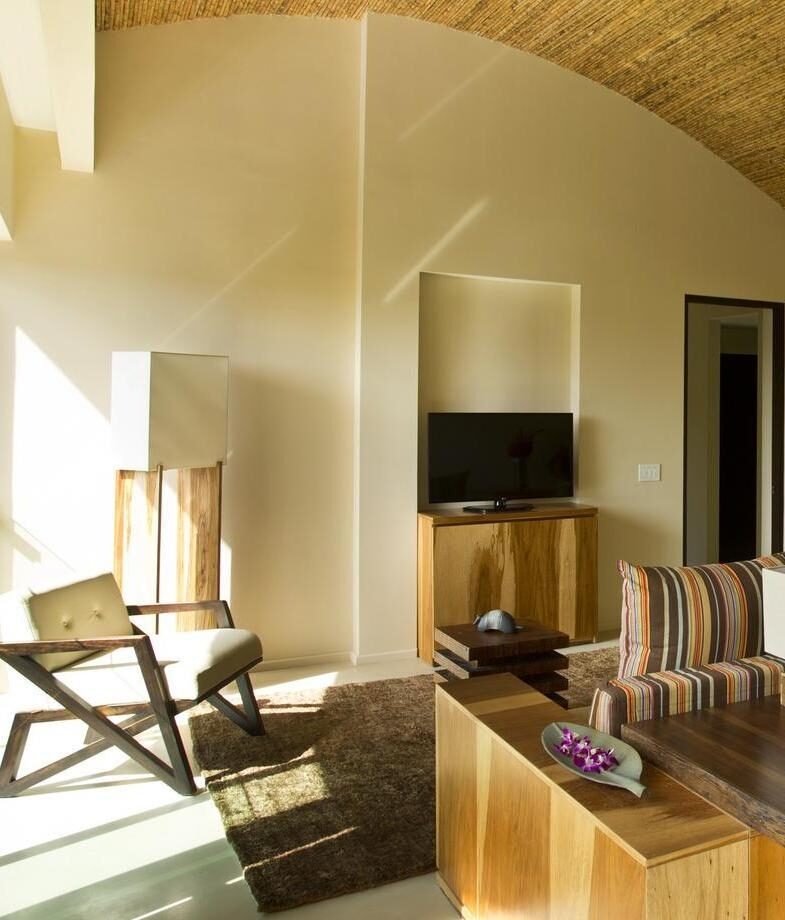 Sunlit living space with natural wood accents at Andaz Papagayo in Guanacaste Coast and a family enjoying a private pool at Nayara Tented Camp in Arenal.