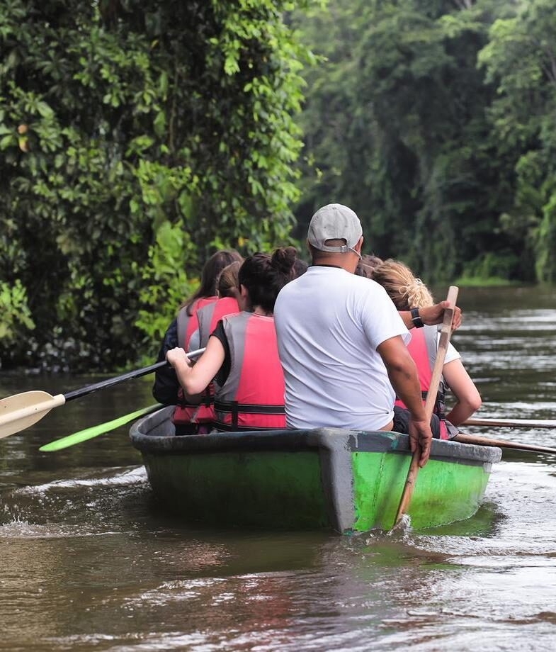 Kayaking through Tortuguero National Park's jungle canals and the main building and pool area at Playa Cativo Lodge on the Osa Peninsula.