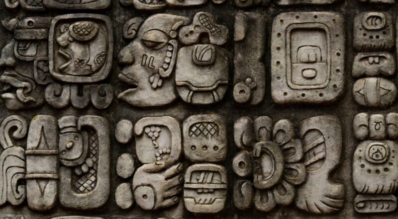 Close-up of ancient stone carvings and Mayan glyphs found on luxury central america tours.