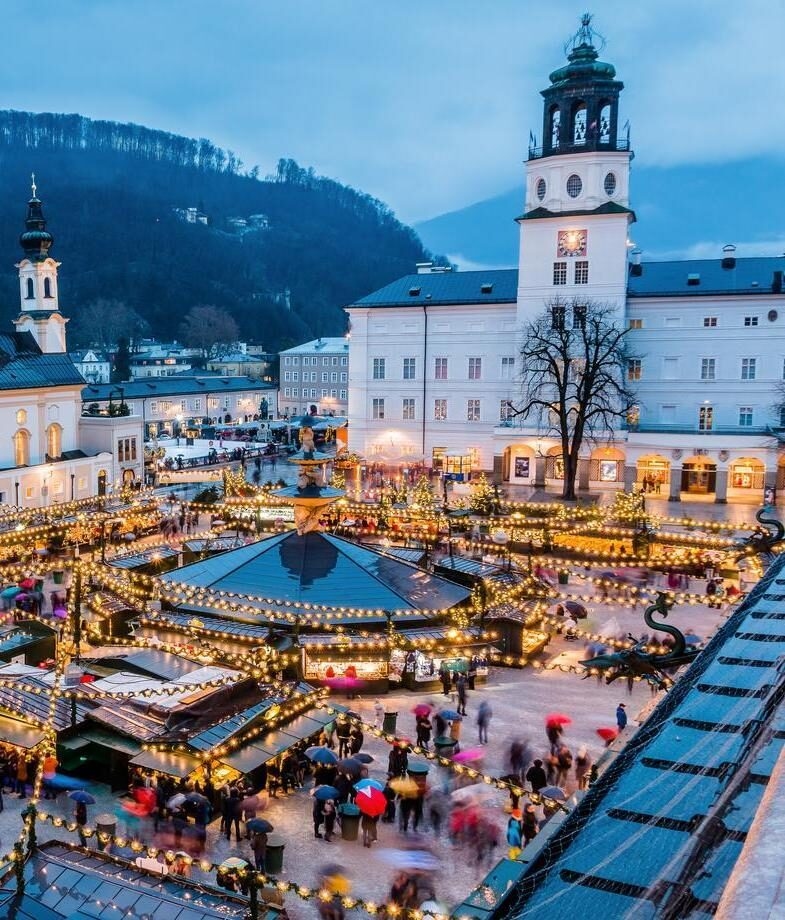 An aerial view of Salzburg’s festive celebrations, Austria, and the market in Cologne Cathedral’s square in Germany, both during Christmas.
