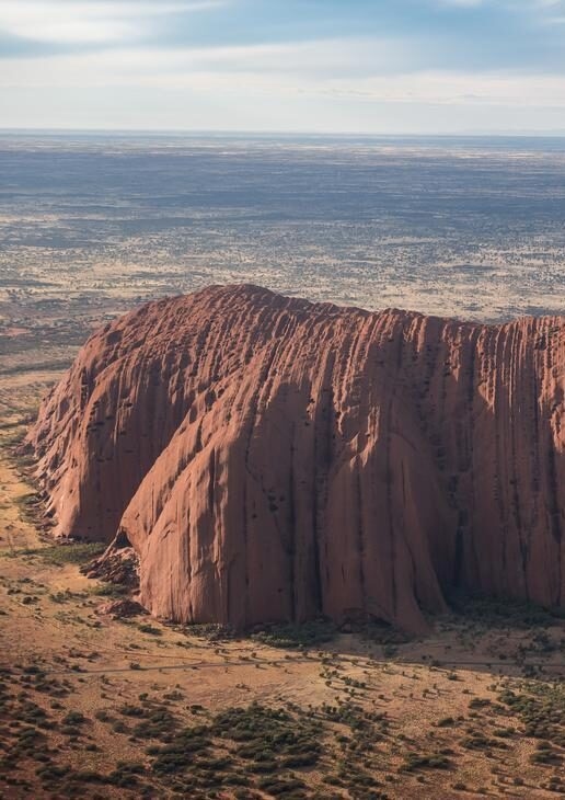 Uluru rising from the desert plains, a kangaroo wandering through vineyards in Adelaide Hills and the first light over Wineglass Bay in Tasmania’s Freycinet National Park.