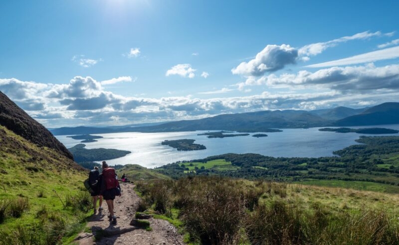 two girls hiking with beautiful lake (loch lomond) and green landscape