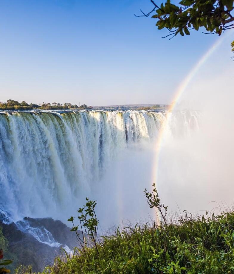 Spot zebra herds on the shimmering salt pans of Botswana’s Makgadikgadi and the rainbow-swept power of Victoria Falls in Zimbabwe during the rainy season.