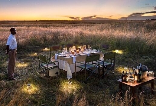 Puku antelopes grazing in Kafue National Park, private dining at King Lewanika Lodge with the vast Liuwa Plain in the background, and an aerial view of the Luangwa River in North Luangwa National Park.