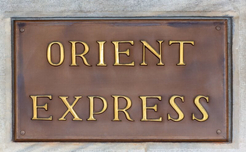 A bronze plaque with the words 'ORIENT EXPRESS' embossed in gold, symbolizing a high-end experience in luxury Europe rail tours.