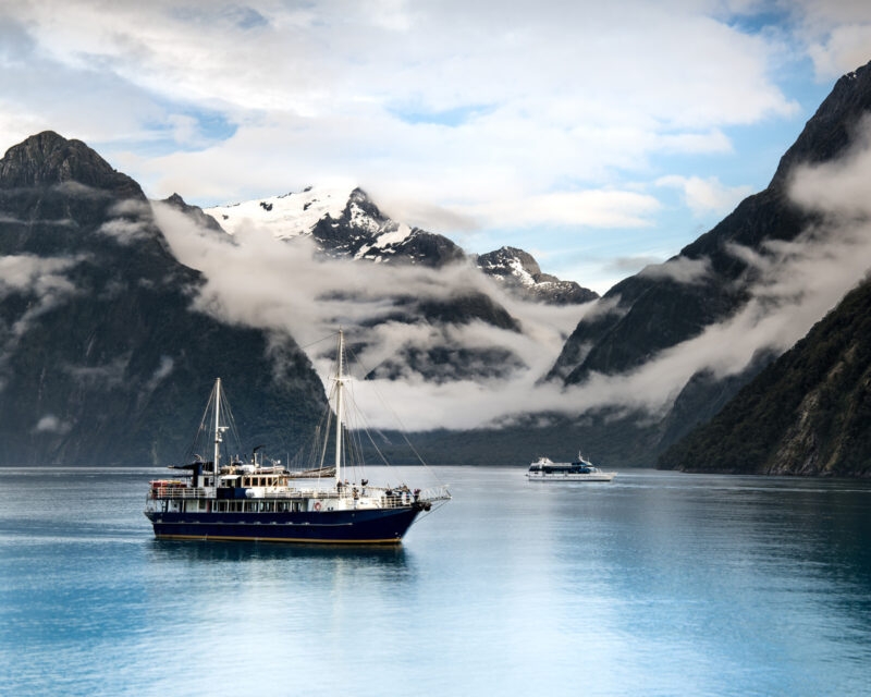 A boat cruising along Milford Sound in New Zealand