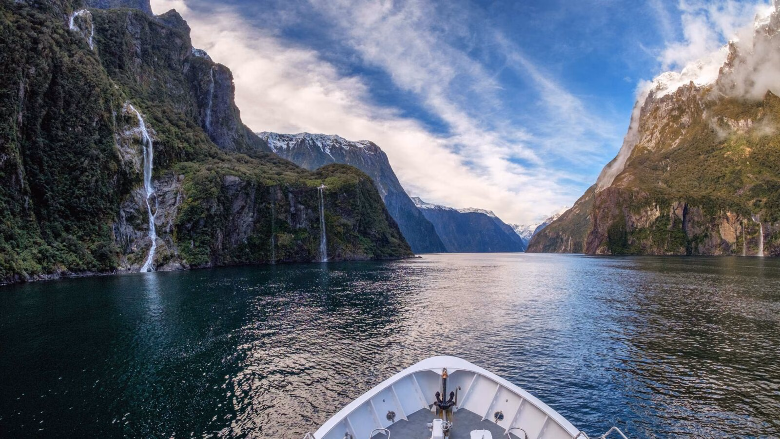 The prow of a boat cruising through Milford Sound in New Zealand