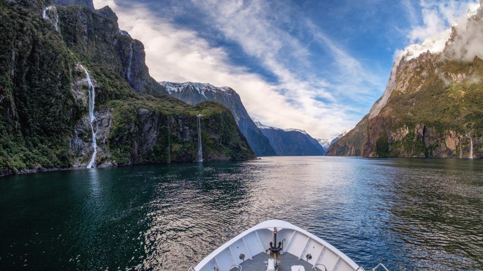 The prow of a boat cruising through Milford Sound in New Zealand