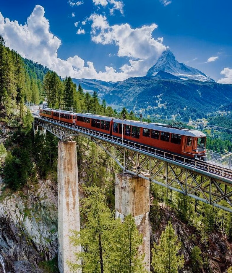 The Glacier Express crossing a mountain bridge in the Swiss Alps with the Matterhorn rising in the distance, and a woman picking tea leaves by hand in Sri Lanka’s highland plantations along the Pekoe Trail.