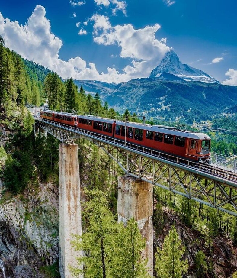 The Glacier Express crossing a mountain bridge in the Swiss Alps with the Matterhorn rising in the distance, and a woman picking tea leaves by hand in Sri Lanka’s highland plantations along the Pekoe Trail.