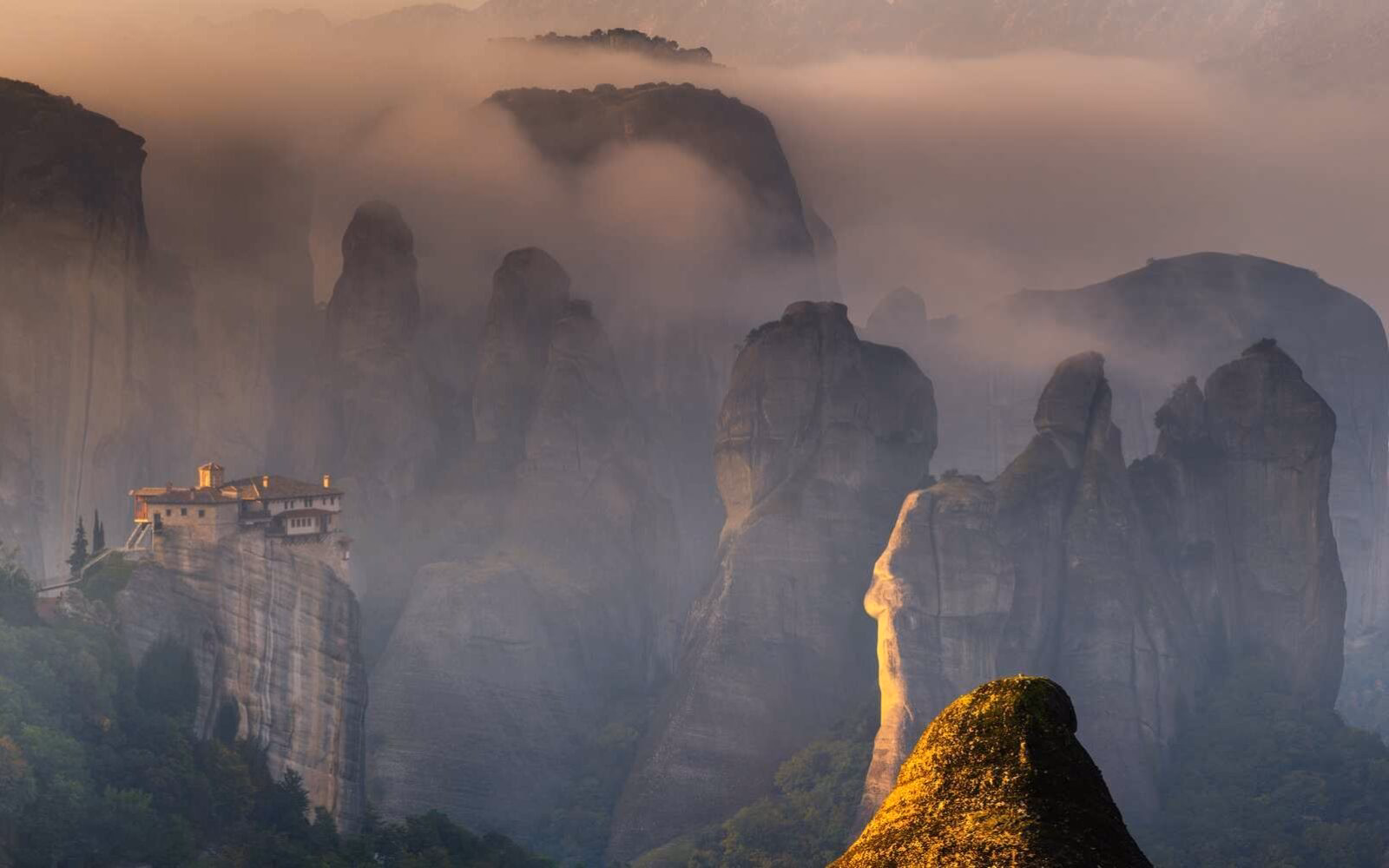 The first rays of sun illuminating the mesmerising mountains of Meteora in northern Greece