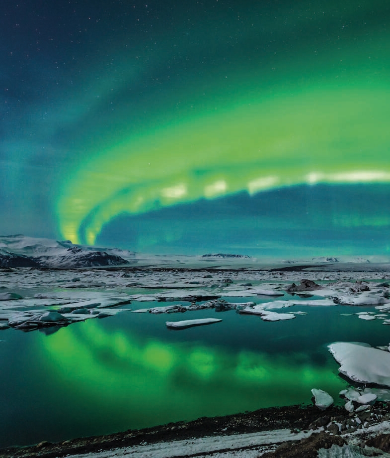 The glowing northern lights shimmering over Iceland’s frozen lakes and the snow-covered Neuschwanstein Castle nestled in Bavaria’s Alps, Germany.