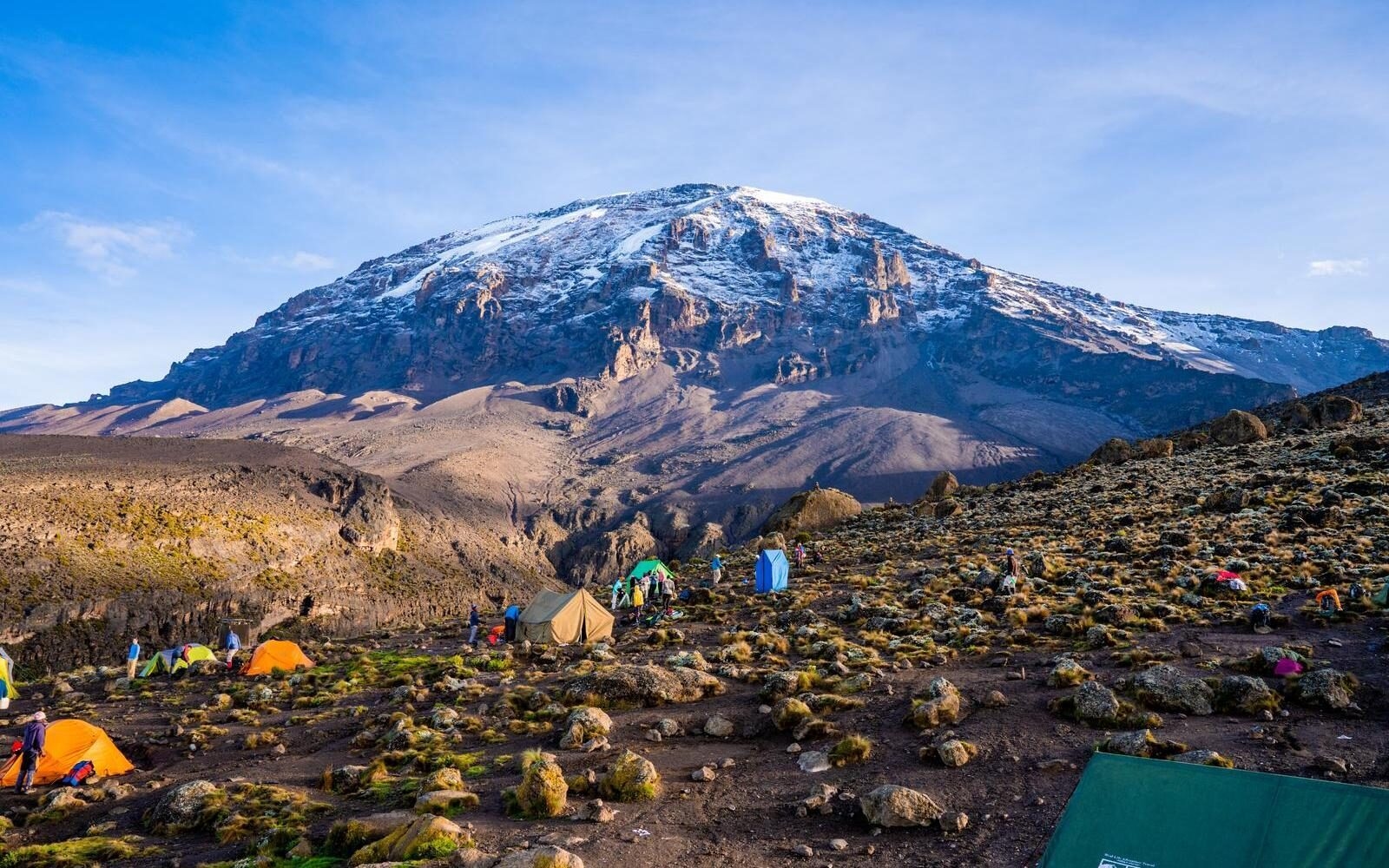 Camping on the slopes of Mount Kilimanjaro beneath its snow-capped summit in Tanzania.