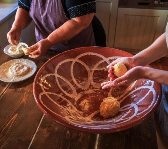 two women kneading dough during a cooking class in Greece