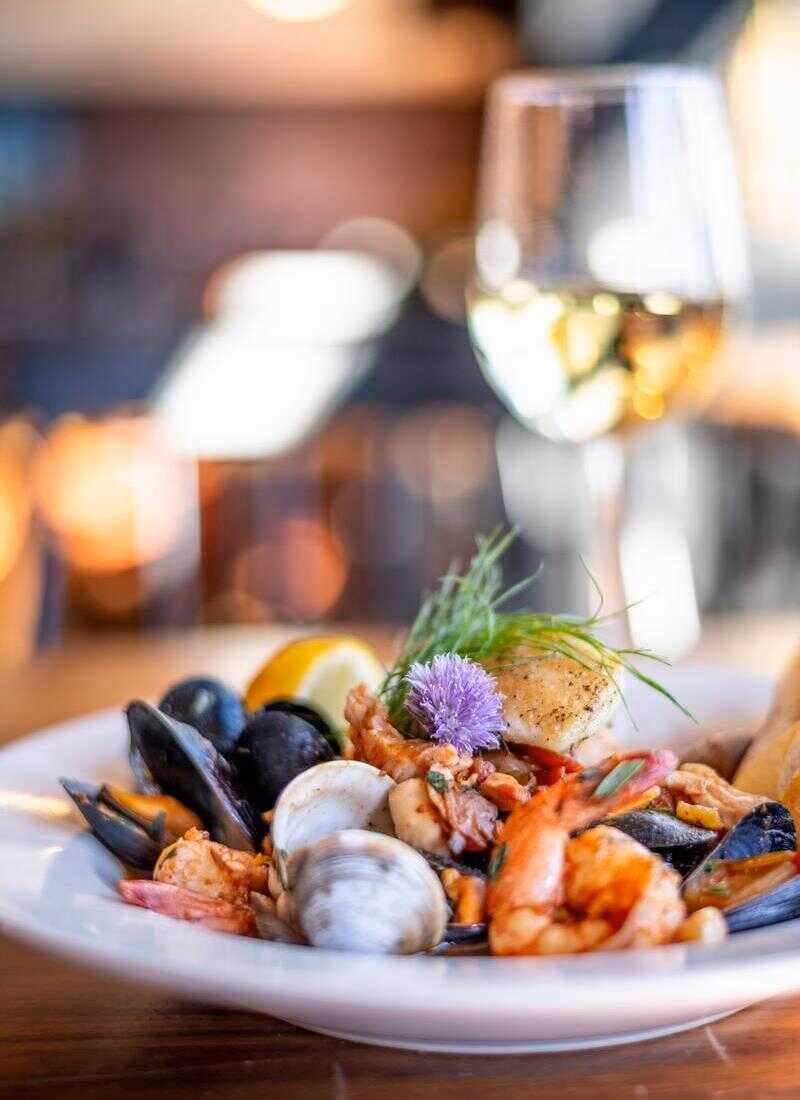 Bouillabaisse seafood stew with a glass of white wine