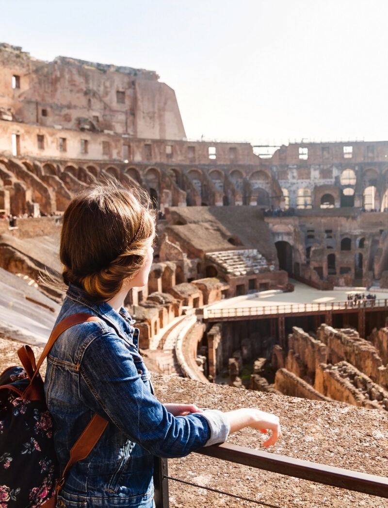 A young woman with a backpack exploring inside the Colosseum