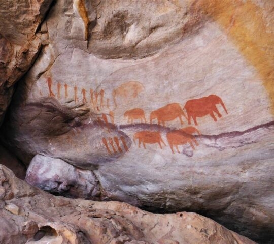 Ancient San rock art painted on a rock in the Cederberg Mountains in South Africa, depicting elephants and people.