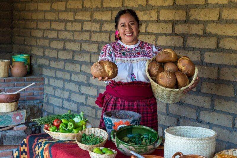 A Zapotec woman in Mexico holding traditional food.