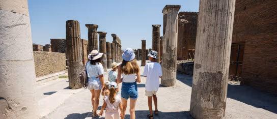 Back of family tourist walking at Pompeii ancient city Italy