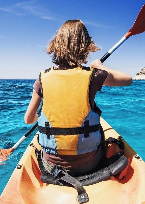 Young girl kayaking in a sea Italy