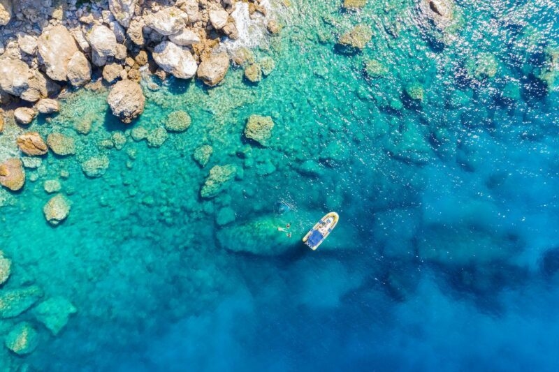 Aerial view of a rib boat with snorkelers and divers at the turquoise colored coast of the Aegean Sea in Greece Greece