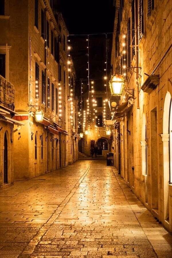Dubrovnik city streets at night, lit with warm lights