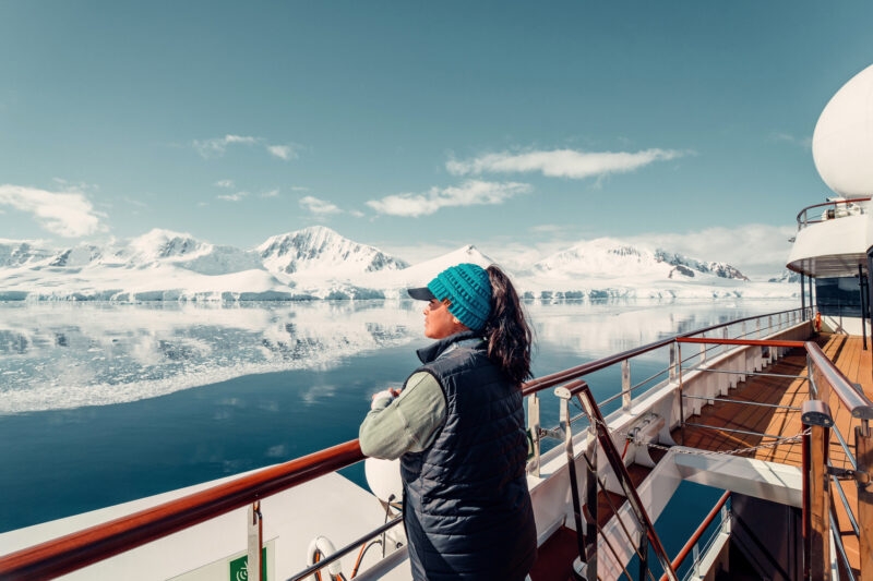 Female Tourist On Huge Luxury Antarctica Cruise Ship Looking Out At The Stunning Scenic Arctic Landscape