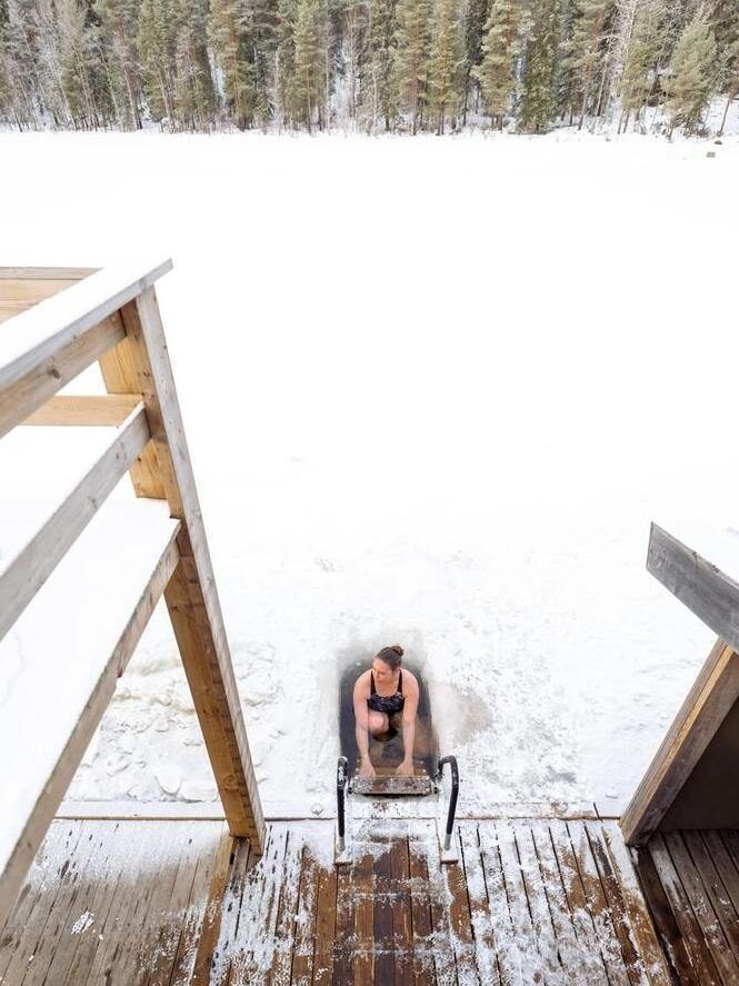 Woman takes an ice dip in a frozen lake in northern Sweden