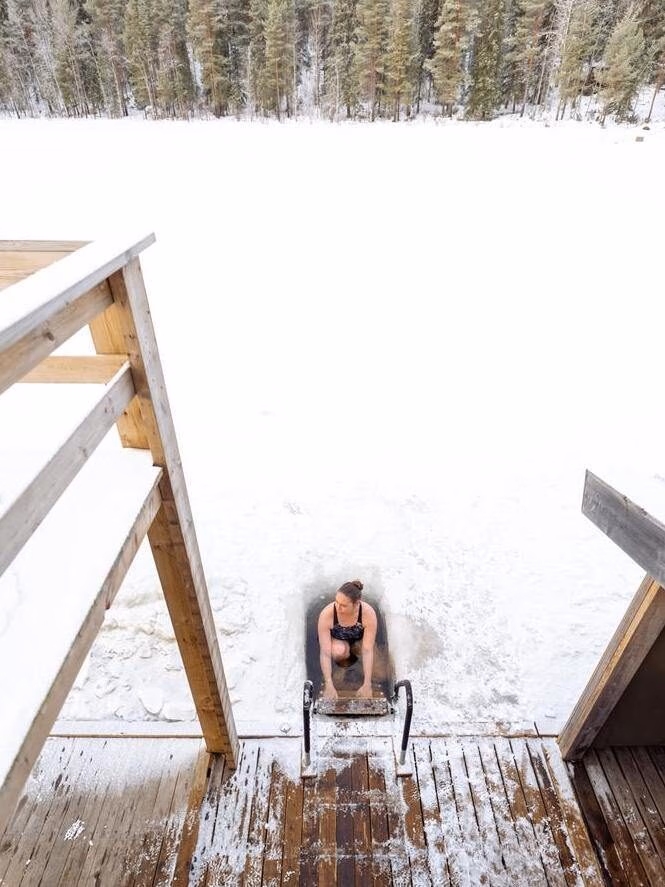 Woman takes an ice dip in a frozen lake in northern Sweden