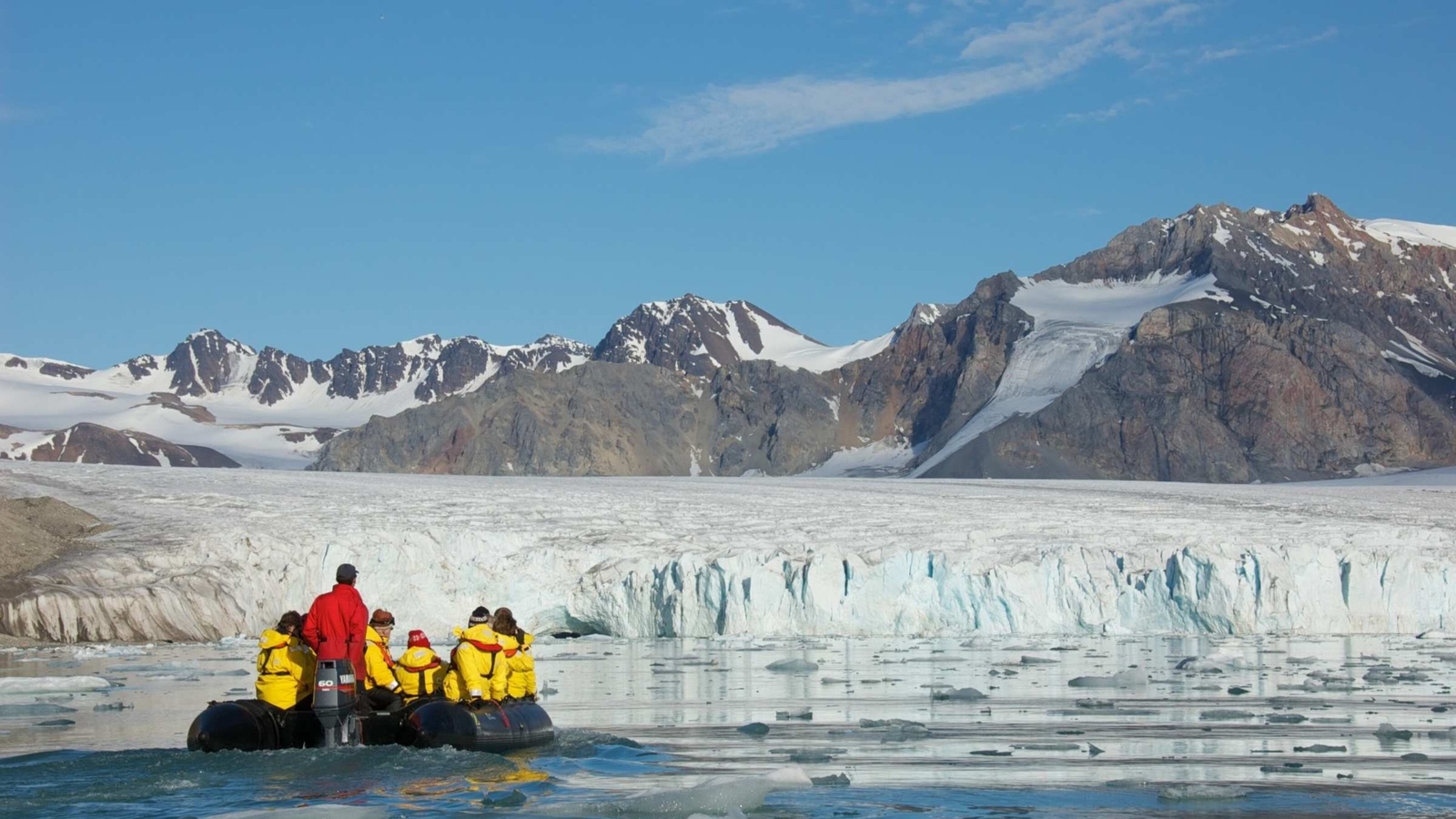 A tour group on a zodiac bat approaching an iceberg in Arctic waters