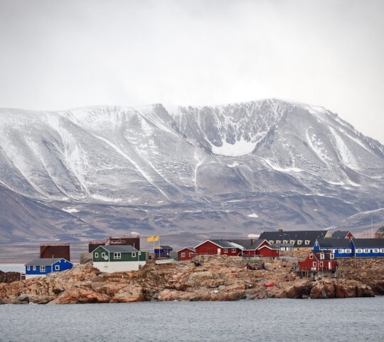A view of the Ittoqqortoormiit settlement in Greenland as seen from the water.