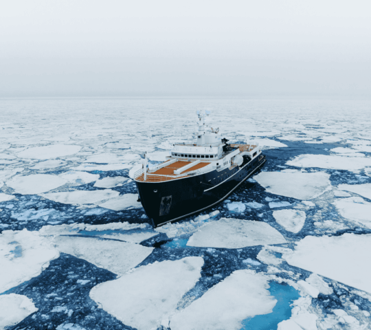 Luxury expedition cruise Aqua Lares drifting between ice in the Arctic.