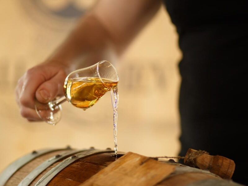 pour whiskey in barrels