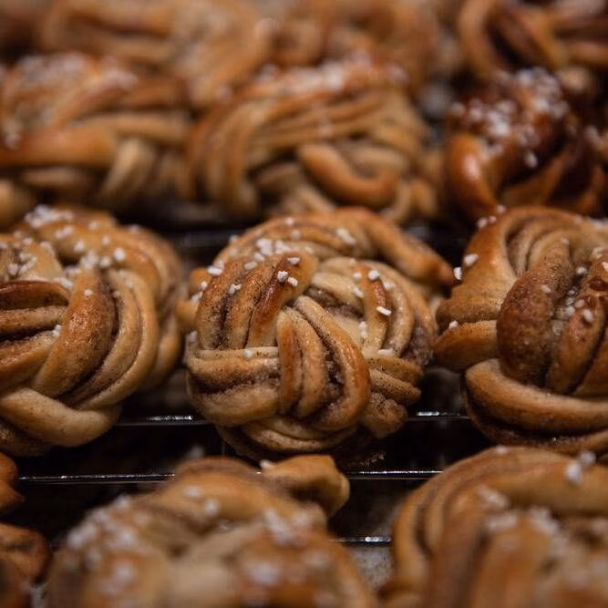 Swedish baked goods. Braided Kardemummabullar, swedish pastries for fika or cardamom rolls, freshly baked and covered in pearl sugar