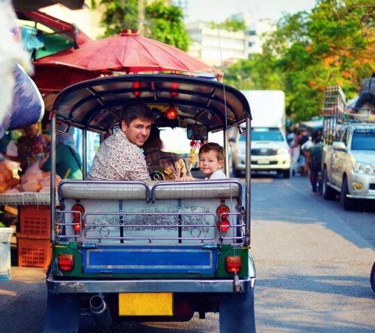 family travel through the asian city on tuk-tuk during a heritage tour