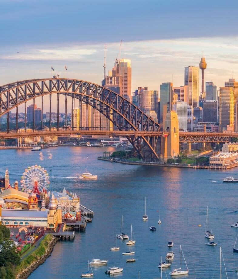 A sweeping view over Cape Town in South Africa, framed by the Atlantic coastline, and Sydney Harbour in Australia at sunset.
