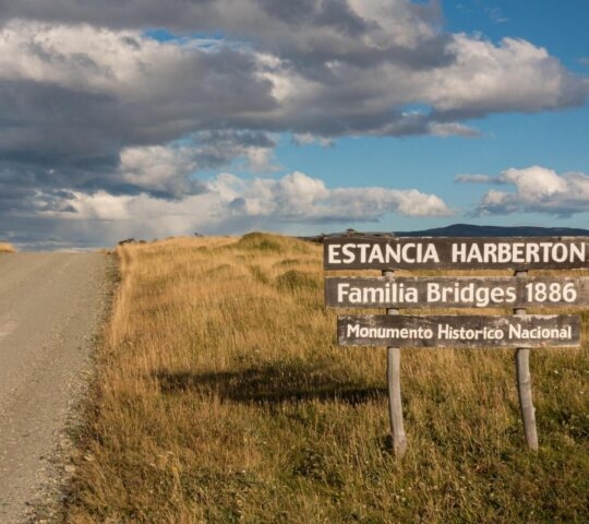 Road sign for Estancia Harberton with grassy plains in the background in Patagonia