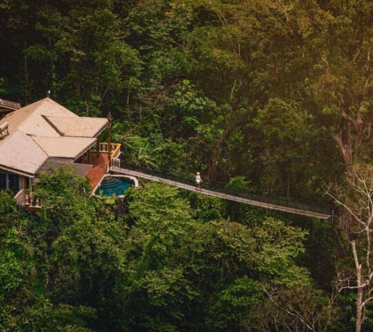 Aerial view of a wooden stilted tent in the middle of the forest at Pacuare Lodge in Costa Rica