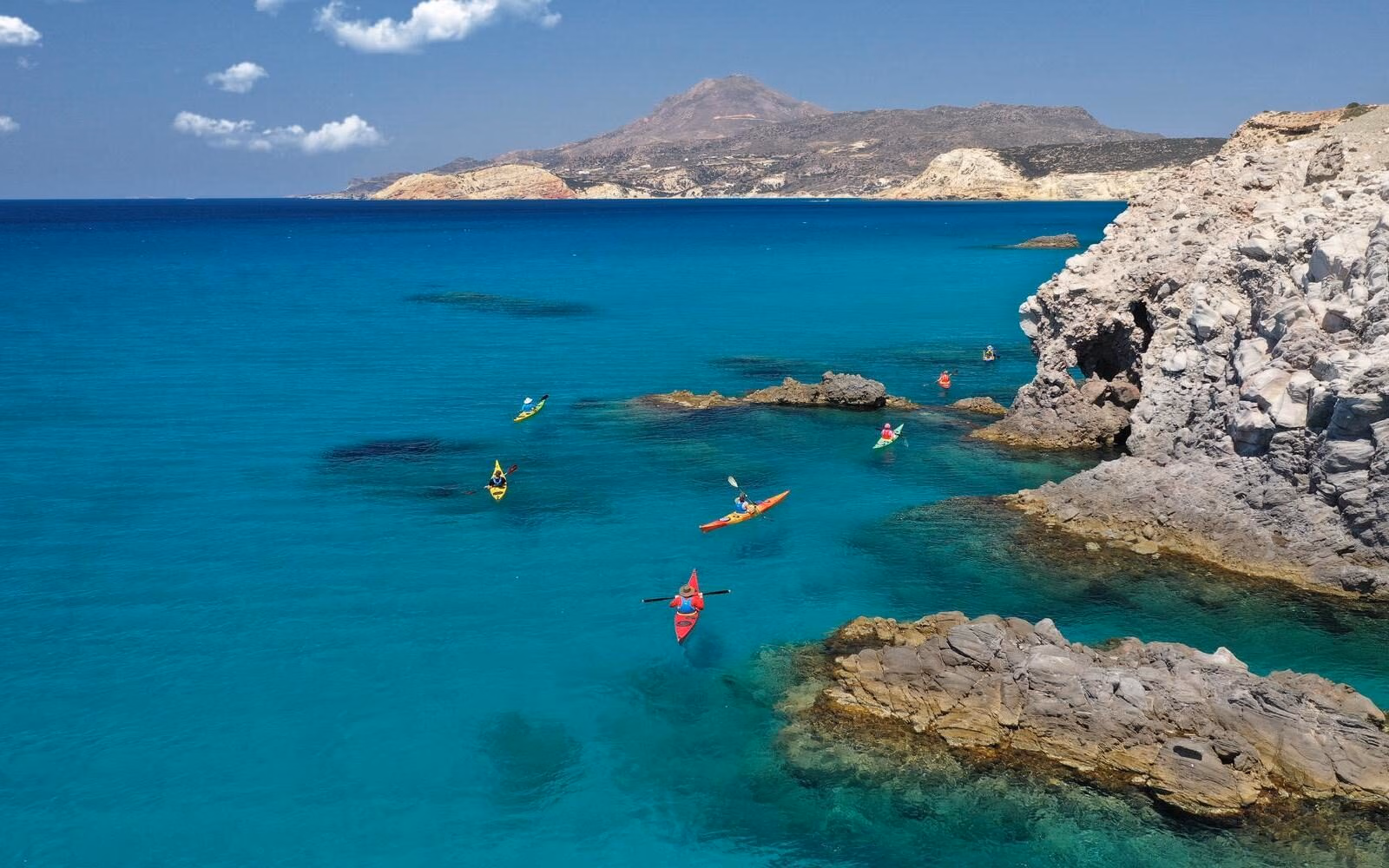 A kayaking experience through the clear blue waters off Milos, alongside the island’s rugged volcanic coastline.
