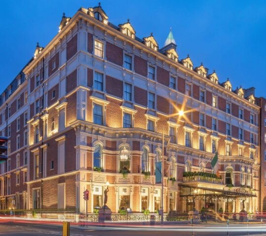 The exterior of the Shelbourne hotel in Dublin lit up at dusk