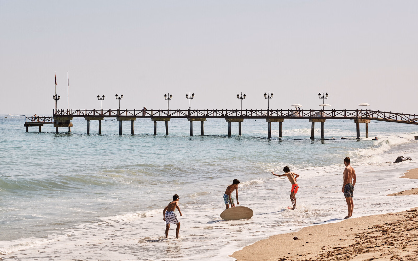 A family enjoying time together on the sandy shore at Marbella Club Hotel in Spain.